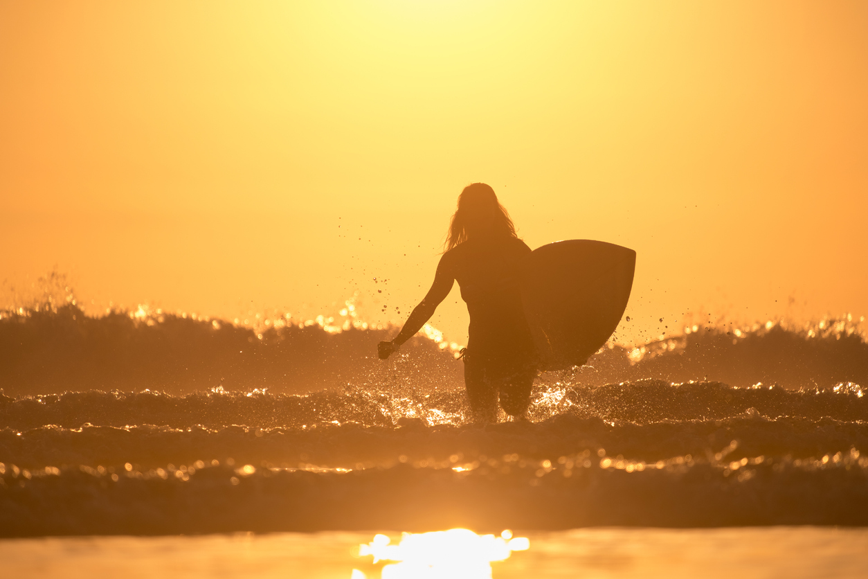 Female Surfer Walks into Surf 